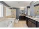 Bright bathroom with a soaking tub, glass shower, and granite countertop vanity at 4852 Merriman Se Walk # 23, Atlanta, GA 30339