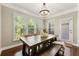 Bright dining room with modern light fixture, a wooden table with bench seating, and ample windows at 4852 Merriman Se Walk # 23, Atlanta, GA 30339