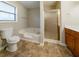 Bathroom featuring a soaking tub, shower with glass door, and a toilet for a relaxing and convenient experience at 895 Tyrell Dr, Austell, GA 30106