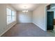 Bright dining room with soft carpet, a chandelier, and a window, creating a welcoming atmosphere at 895 Tyrell Dr, Austell, GA 30106