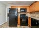 Kitchen featuring black appliances, wood cabinetry, and tile backsplash at 895 Tyrell Dr, Austell, GA 30106