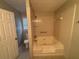 Bathroom with white tiled shower-tub combo, white toilet, and natural light from the window at 1430 Country Lane Ne Dr, Conyers, GA 30012