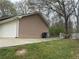 Side view of home showing tan siding and back of garage with trash can at 1430 Country Lane Ne Dr, Conyers, GA 30012