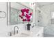 Bright bathroom featuring double sinks, white cabinets, illuminated mirror, and glass walk-in shower with marble tile at 1967 Nash Se Ave, Atlanta, GA 30316