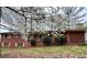 Charming red brick home featuring blossoming trees in a mature landscaped front yard at 6079 Zachary Ct, Norcross, GA 30093