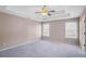 Spacious main bedroom with a tray ceiling, ceiling fan, neutral walls, and plush carpet at 1784 Hollingsworth Nw Blvd, Atlanta, GA 30318