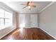 Sunlit bedroom with hardwood floors, large window, ceiling fan, and convenient closet space at 2619 Del Ridge Dr, Douglasville, GA 30135