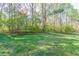 Wide view of a large, grassy yard with a tree line in the background, ready for landscaping and recreation at 2619 Del Ridge Dr, Douglasville, GA 30135