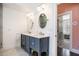 Bathroom features a modern double vanity, dual oval mirrors, and doorway to a walk-in closet at 323 Fayetteville Rd, Decatur, GA 30030
