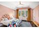 Comfortable bedroom with pink walls, tray ceiling, decorative rug, and charming, colorful bedspread at 323 Fayetteville Rd, Decatur, GA 30030
