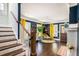Bright and airy living room with wooden floors, colorful accents, and staircase at 323 Fayetteville Rd, Decatur, GA 30030
