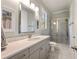 Well-lit bathroom with a marble countertop, gray cabinets, and a glass-enclosed shower at 3669 High Green Dr, Marietta, GA 30068