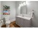 Elegant powder room with a gray vanity, white countertop, and stylish fixtures and palm tree artwork at 3669 High Green Dr, Marietta, GA 30068