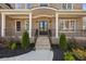 Covered front porch featuring an elegant double door entrance with black metal railings and stone stairs at 3669 High Green Dr, Marietta, GA 30068