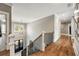 Hallway with wood floors and black metal stair rail, leading to the front door and other rooms at 3669 High Green Dr, Marietta, GA 30068
