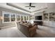 Bright living room featuring a ceiling fan, built-in shelves and cabinets, and an expansive view of trees through large windows at 3669 High Green Dr, Marietta, GA 30068