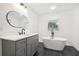 Contemporary bathroom featuring a soaking tub, dark tiled floor, and a vanity with marble countertop at 8671 Lake Forrest Dr, Douglasville, GA 30134