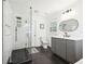 Modern bathroom featuring a glass-enclosed shower, sleek vanity, and black tiled floor at 8671 Lake Forrest Dr, Douglasville, GA 30134