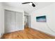 Bedroom with hardwood floors, ceiling fan, and TV; featuring a closet and ensuite entrance at 8671 Lake Forrest Dr, Douglasville, GA 30134