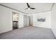 Carpeted bedroom with ceiling fan, TV, and access to a bathroom at 8671 Lake Forrest Dr, Douglasville, GA 30134