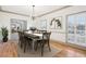 Bright dining room featuring hardwood floors, stylish chandelier, and large shuttered windows at 8671 Lake Forrest Dr, Douglasville, GA 30134