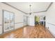 Bright dining room with hardwood floors, modern light fixture and view into kitchen at 8671 Lake Forrest Dr, Douglasville, GA 30134