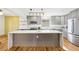 Modern kitchen with stainless steel appliances, gray cabinets, and center island at 8671 Lake Forrest Dr, Douglasville, GA 30134