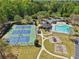 Aerial view of the community tennis courts, a pool and a playground surrounded by mature trees and landscaping at 1191 Crofton Lndg, Suwanee, GA 30024