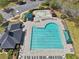 A community pool with a splash pad, a pool house and many lounge chairs sits near a parking lot and landscaping at 1191 Crofton Lndg, Suwanee, GA 30024