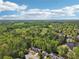 Overhead view of a neighborhood surrounded by lush greenery with a pond and walking path at 1191 Crofton Lndg, Suwanee, GA 30024
