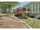 Landscaped backyard with lush green grass, mature trees, retaining wall, and a deck at 1191 Crofton Lndg, Suwanee, GA 30024