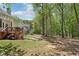 Spacious backyard features a deck, mature trees, grass, and a retaining wall at 1191 Crofton Lndg, Suwanee, GA 30024
