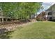 Landscaped backyard with lush green grass, mature trees, and a retaining wall at 1191 Crofton Lndg, Suwanee, GA 30024
