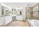 Elegant bathroom featuring double sinks, soaking tub, and frameless shower at 1191 Crofton Lndg, Suwanee, GA 30024