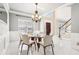 Elegant dining room with a glass table and modern chandelier near the home's entryway and staircase at 1191 Crofton Lndg, Suwanee, GA 30024