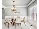 Elegant dining room featuring a modern chandelier, a round glass table, and bright natural light at 1191 Crofton Lndg, Suwanee, GA 30024