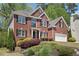 Elegant brick home with manicured landscaping, black shutters, and an attached two-car garage at 1191 Crofton Lndg, Suwanee, GA 30024
