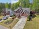 Aerial view of a well maintained brick two story home and front yard in a lush green neighborhood at 1191 Crofton Lndg, Suwanee, GA 30024