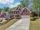 Charming two-story brick home with a manicured lawn and a two-car garage at 1191 Crofton Lndg, Suwanee, GA 30024