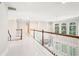 Bright hallway with white tile floors and wood railings, featuring views from arched windows at 1191 Crofton Lndg, Suwanee, GA 30024