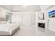 Primary bedroom showcasing white tile floors, fireplace and tv mounted above, and white trim at 1191 Crofton Lndg, Suwanee, GA 30024