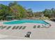 A large swimming pool with multiple deck chairs and tables is surrounded by trees in this neighborhood at 1191 Crofton Lndg, Suwanee, GA 30024