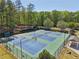 A neighborhood tennis court with three courts is surrounded by a tall fence and mature shade trees at 1191 Crofton Lndg, Suwanee, GA 30024