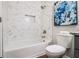 This bathroom boasts a tiled shower and tub alongside modern toilet and blue art accents, making it modern at 1857 Taffeta Trl, Lithonia, GA 30058