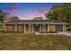 Charming brick home with a well-manicured lawn and inviting front entrance at sunset at 1857 Taffeta Trl, Lithonia, GA 30058