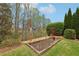 View of the backyard showing a small gardening bed filled with soil and greenery at 1870 Marcia Overlook Dr, Cumming, GA 30041