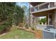 View of the backyard with a wooden deck above a concrete patio and landscaped yard at 1870 Marcia Overlook Dr, Cumming, GA 30041
