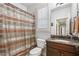 Well-lit bathroom with a granite countertop, dark wood cabinets and a shower with neutral-toned curtain at 1870 Marcia Overlook Dr, Cumming, GA 30041
