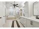 Spacious bathroom featuring tile floors, double vanities, a soaking tub, and a glass shower at 1870 Marcia Overlook Dr, Cumming, GA 30041
