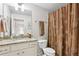 Well-lit bathroom featuring a vanity with a granite countertop and a shower with a decorative floral curtain at 1870 Marcia Overlook Dr, Cumming, GA 30041